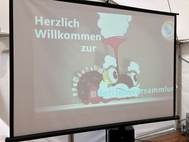 Begrüßungsfolie Betriebsversammlung der DB Wanne-Eickel mit gezeichneter Dampflok. Stefan Sosnowski von der DEVK in Duisburg informiert über aktuelle Themen der DEVK und den Pensionsfonds.