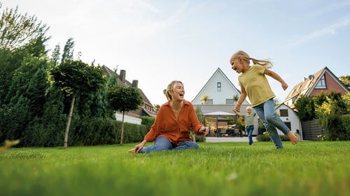 Fröhliche Familie im Garten hinter dem Haus