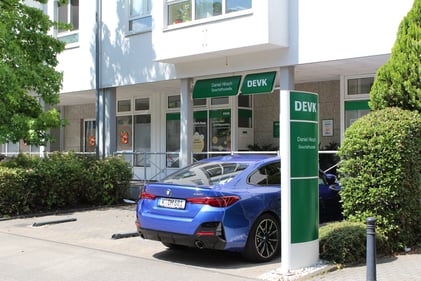 Außenaufnahme der Geschäftsstelle mit Parkplatz und PKW.