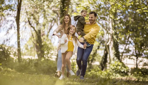 Familie ist gemeinsam in der Natur unterwegs und verbringt Zeit im sonnigen Wald.