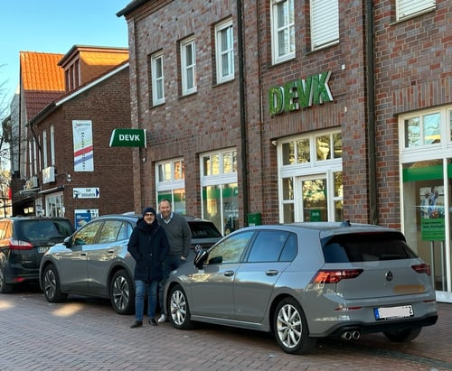 DEVK Frontansicht mit Norbert und Holger neben einem schönen Firmenwagen