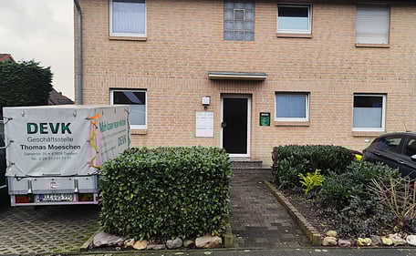 Mann Sieht den Eingang mit dem DEVK Anhänger und dem Firmenschild