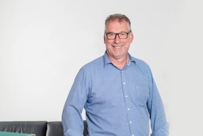 Der Gebietsdirektor Norbert Mohr in blauen Hemd, mit seiner Brille, lächelnd.