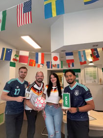 Das Foto zeigt das Team der DEVK Agentur Manuel Brühn in Trikots der deutschen Fußballnationalmannschaft, lächelnd und jubelnd.