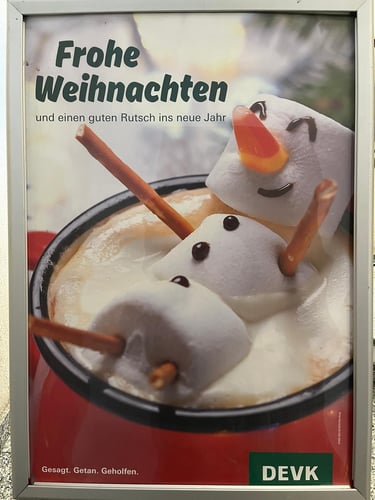 Foto eines Schneemanns mit dem Schriftzug Frohe Weihnachten