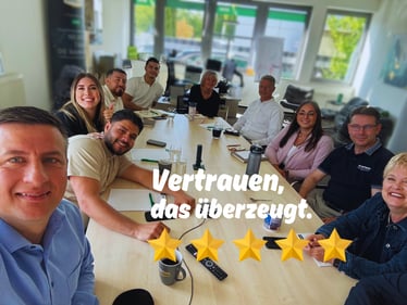 Bild des gesamten Teams der DEVK Sebastian Pfeil am Besprechungstisch sitzend