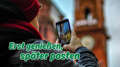 Person fotografiert mit dem Smartphone in einer Stadt zum Beitrag „Urlaubsbilder posten? Warum etwas Zurückhaltung sinnvoll sein kann“ der DEVK Agentur Marco Hock