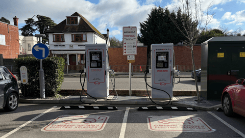 Two InstaVolt EV chargers in a McDonald's car park in Farnborough, with designated EV charging bays marked on the ground. A Ford Mears Funeral Directors building is visible in the background.