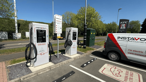 InstaVolt ultra-rapid EV charging station with two chargers beside a KFC drive-thru in Kingswinford on a sunny day.