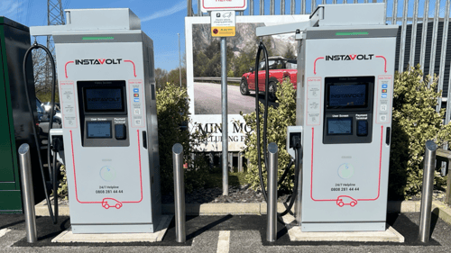 Two InstaVolt rapid EV chargers installed at a McDonald’s car park, ready for use under clear blue skies.