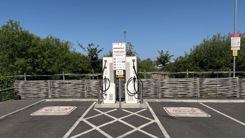 InstaVolt dual ultra rapid EV chargers at McDonald’s Bridgwater with marked bays and rural wooden fencing in the background.
