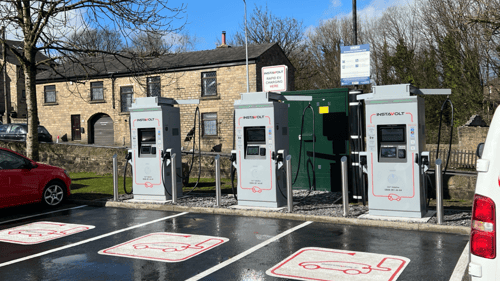 InstaVolt EV charging bays at McDonald's, Waters Meeting Road, Bolton, with multiple charging stations and parking spaces under a bright blue sky.