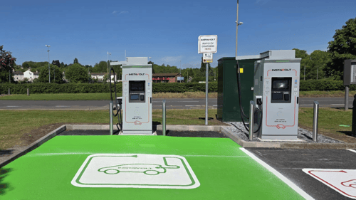 InstaVolt ultra rapid EV chargers at Abbey Lane, Leicester with green EV bays under clear blue skies.