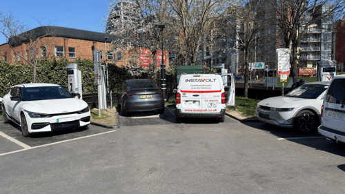 EV drivers charging at InstaVolt rapid chargers at McDonald's Wandsworth, with multiple electric vehicles including a Tesla and Kia.