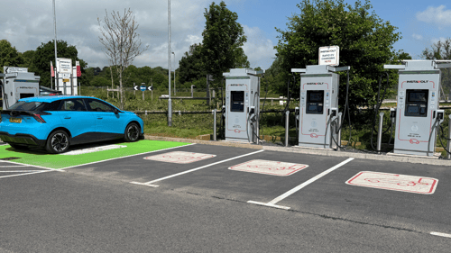 Blue electric vehicle charging at InstaVolt ultra rapid chargers in Wincanton off the A303.