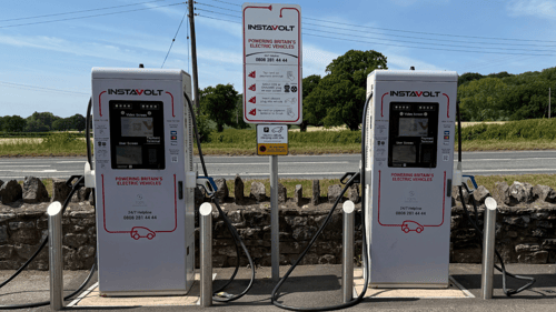 Two InstaVolt ultra rapid EV chargers at Lye Cross Farm on the A38 in Redhill, Bristol, with countryside in the background.