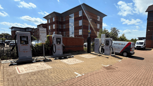 InstaVolt ultra-rapid EV chargers at Sorbonne Close, Thornaby, with visible charging bays and nearby business offices under a clear blue sky.
