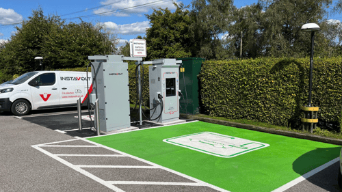 A pair of InstaVolt ultra-rapid chargers beside a branded InstaVolt van at The Hampshire Hog, EV-only parking bays.