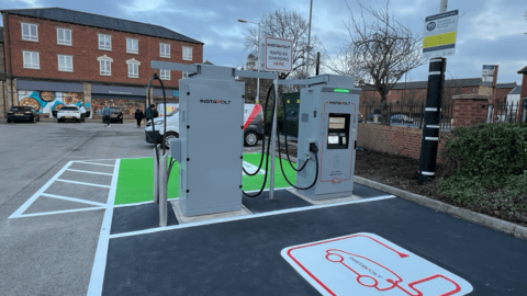 InstaVolt ultra rapid EV chargers at Co-op Ossett, located in a well-marked charging bay with green parking spaces and clear signage. The Co-op store and other retail shops are visible in the background.