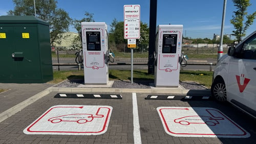 Two InstaVolt ultra rapid EV chargers at Leathermill Lane in Rugeley with marked parking bays under clear skies.