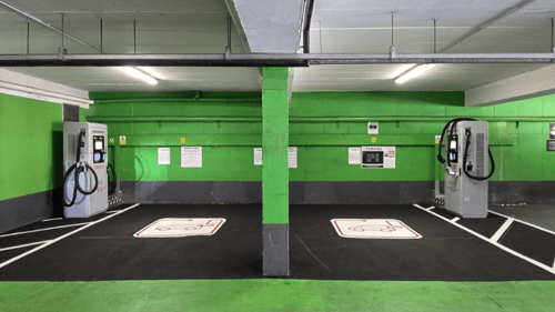 Close-up view InstaVolt ultra-rapid EV chargers against a green wall in an indoor car park.