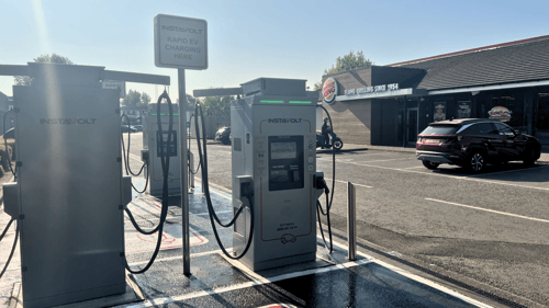 InstaVolt rapid EV chargers in a car park beside a Burger King restaurant at Cowley Retail Park, Oxford. A car is parked nearby, and the area is clearly marked for EV charging.