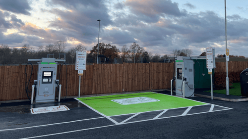InstaVolt ultra-rapid EV chargers at McDonald’s Fairhill Bedford site with clear green parking bays and signage, captured at dusk under a cloudy sky.