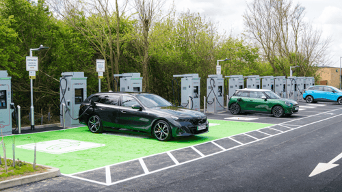 Electric vehicles charging at InstaVolt ultra rapid chargers in Caxton, Cambridgeshire, with dedicated green EV bays and multiple charging units in view.