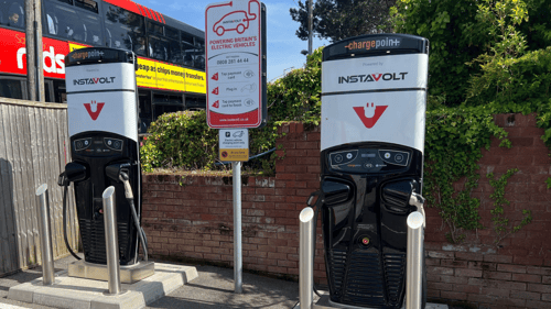 InstaVolt electric vehicle charging units at London Road, Amesbury, with clear branding, dual connectors, and instructions for tap payment visible in the foreground.