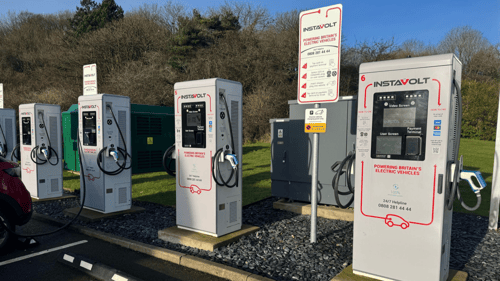 Row of InstaVolt ultra rapid EV chargers at KFC Lakeside in Oldbury, set beside green space and supported by clear signage for easy public access.