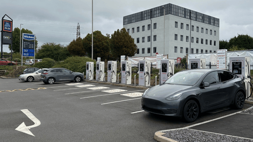 Ultra-rapid InstaVolt EV chargers at Wickes Dudley, with a Tesla Model Y charging and nearby signage for Aldi and Wickes.