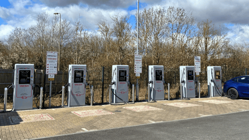 Overview of InstaVolt ultra rapid EV charging bays at Greggs Drive-Thru, Carterton, showing six chargers with designated parking spaces.