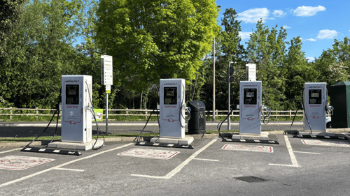 InstaVolt ultra rapid EV chargers at McDonald’s Cribb Causeway in Bristol, with four charging bays clearly marked and surrounded by green trees under a clear sky.