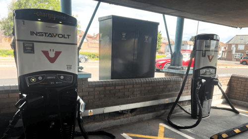 Two InstaVolt rapid EV charging units installed in a covered car park, with charging cables and signage visible.