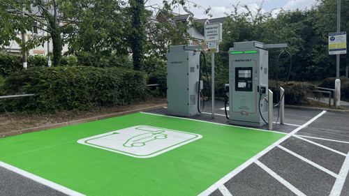 Ultra-rapid InstaVolt EV chargers at Newport Street, Hay-on-Wye car park surrounded by greenery.