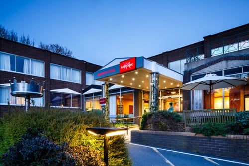 Exterior shot of Mercure Norwich Hotel, hotel entrance walkway at dusk.