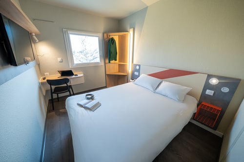 Chambre double rénovée à l’hôtel ibis budget Narbonne Est, avec lit confortable, décoration moderne et teintes apaisantes, idéale pour un séjour économique et reposant à Narbonne.
